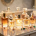 Collection élégante de flacons de parfum féminins disposés sur une coiffeuse lumineuse, ambiance chic et raffinée, reflets doux sur le verre.