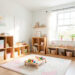 Chambre d’enfant lumineuse avec rangements en bois, espace de jeu dégagé et décoration douce aux couleurs pastel.