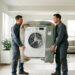 Deux déménageurs transportent avec précaution un lave-linge et un réfrigérateur protégés dans un intérieur lumineux.