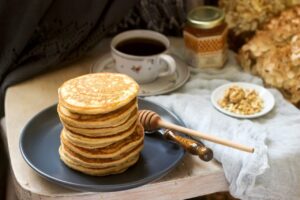 Assiette de crêpes à la farine complète servies avec des fruits frais pour un petit-déjeuner équilibré.